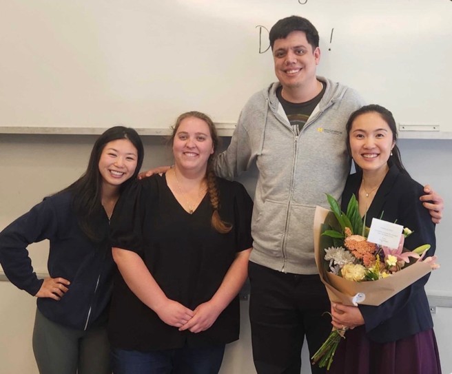 Joanna Lum at her thesis defense with cohort members, Caroline, Koral, and Ismael.